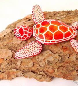 manualidad de tortuga pintada en piedras rojas