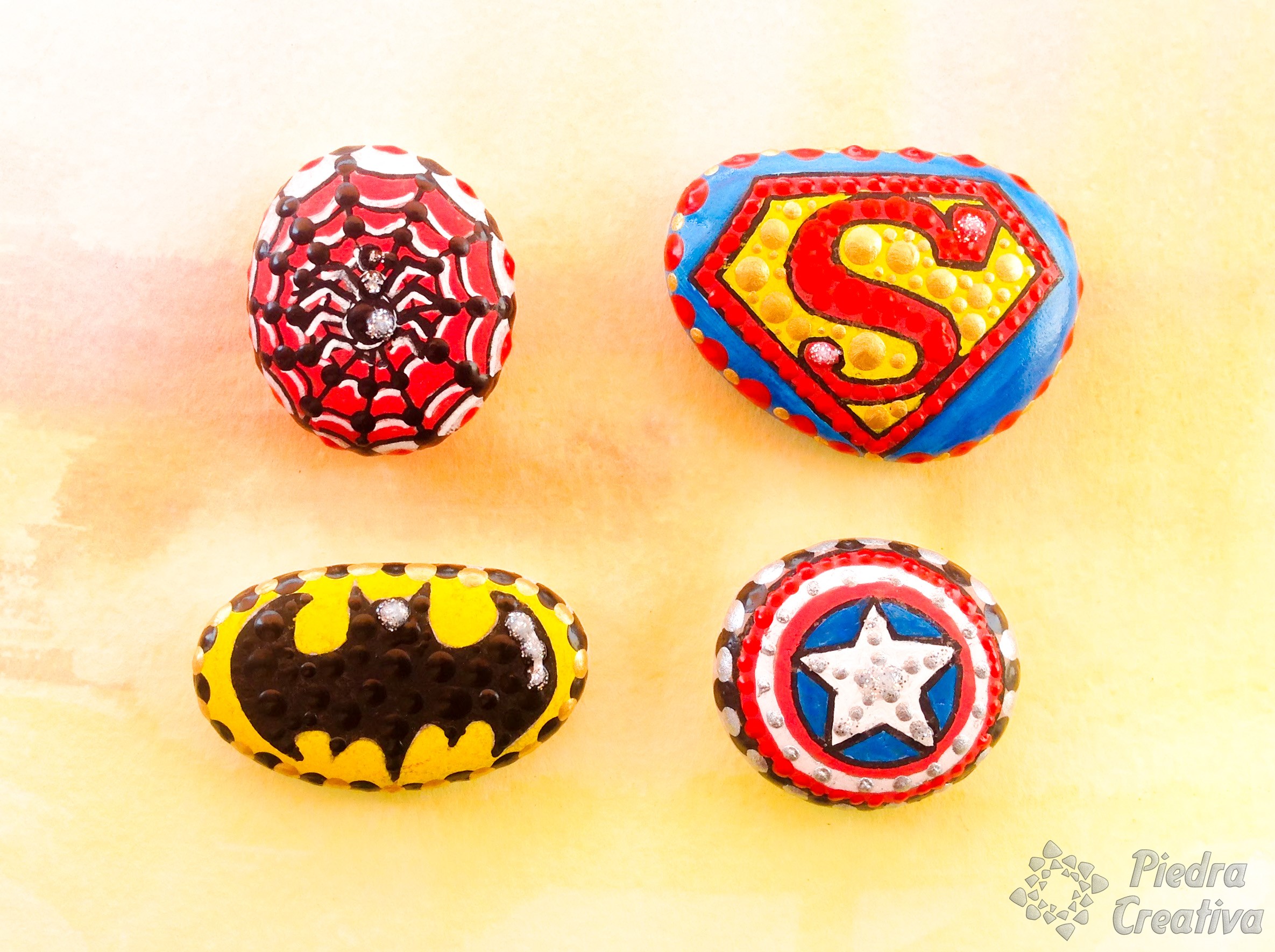 Logos de superheroes en piedras pintadas